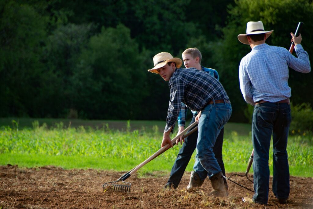 man in blue and white plaid dress shirt holding shovel