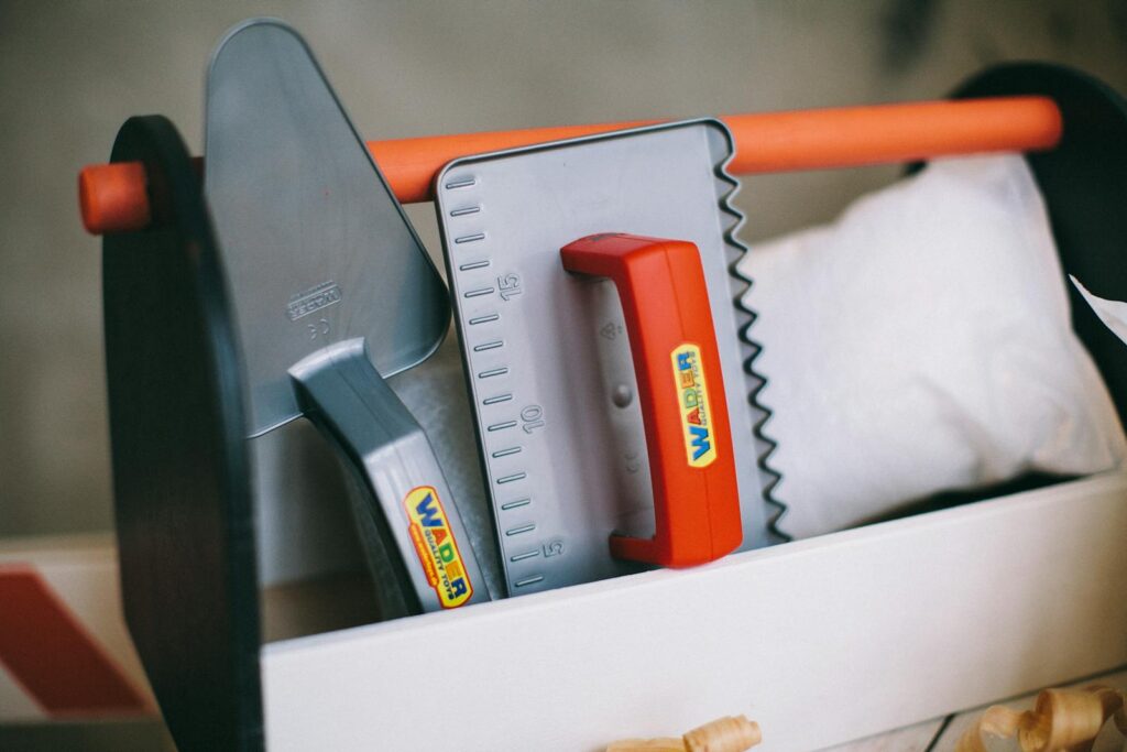 Vibrant plastic toy toolkit featuring trowel and square. Perfect for imaginative play.