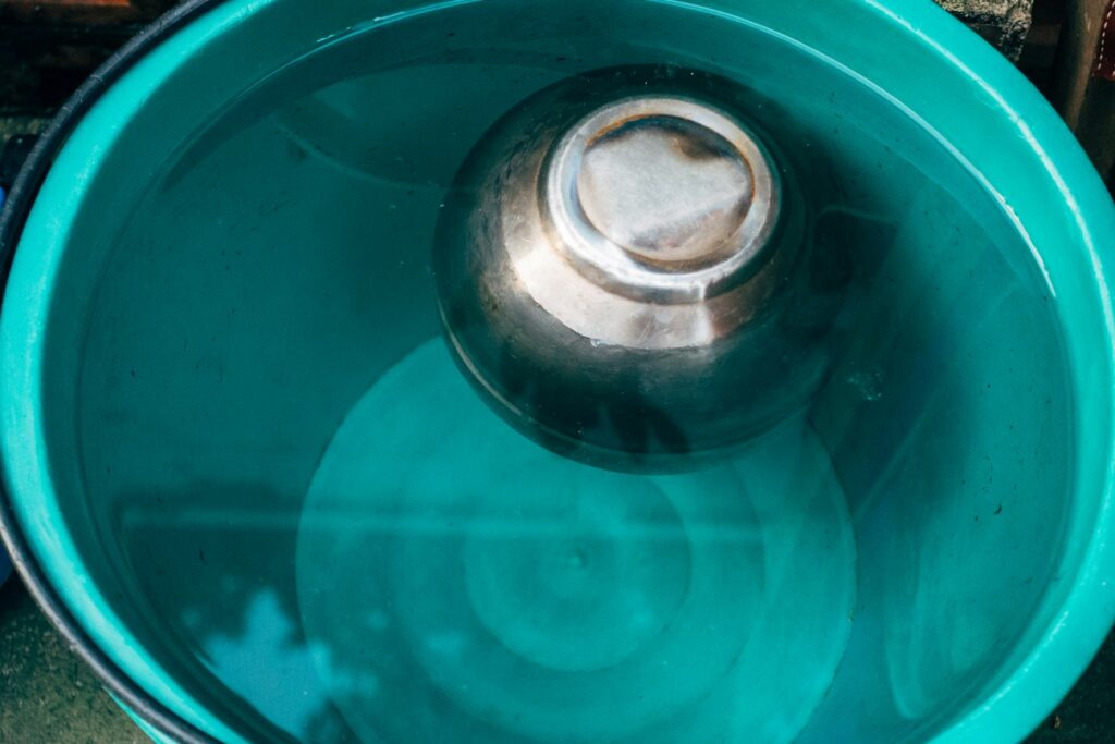 a blue metal bowl with a metal lid