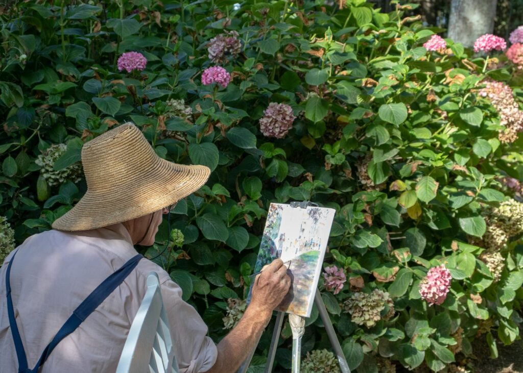 person in brown hat holding white book