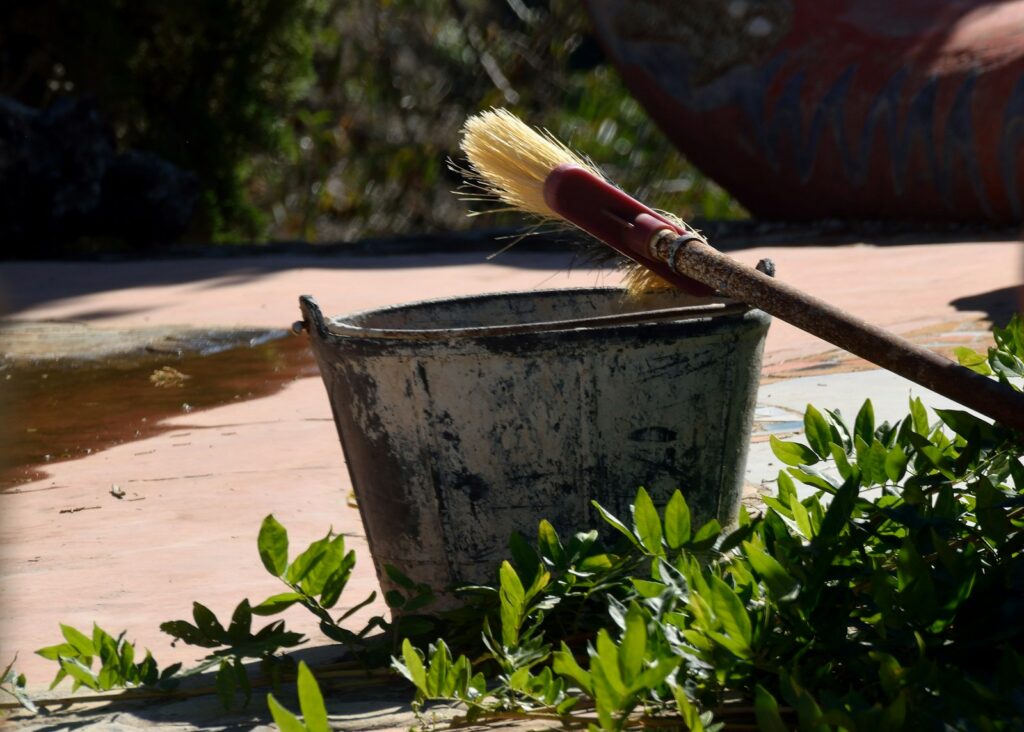 a brush sits in a bucket on the ground