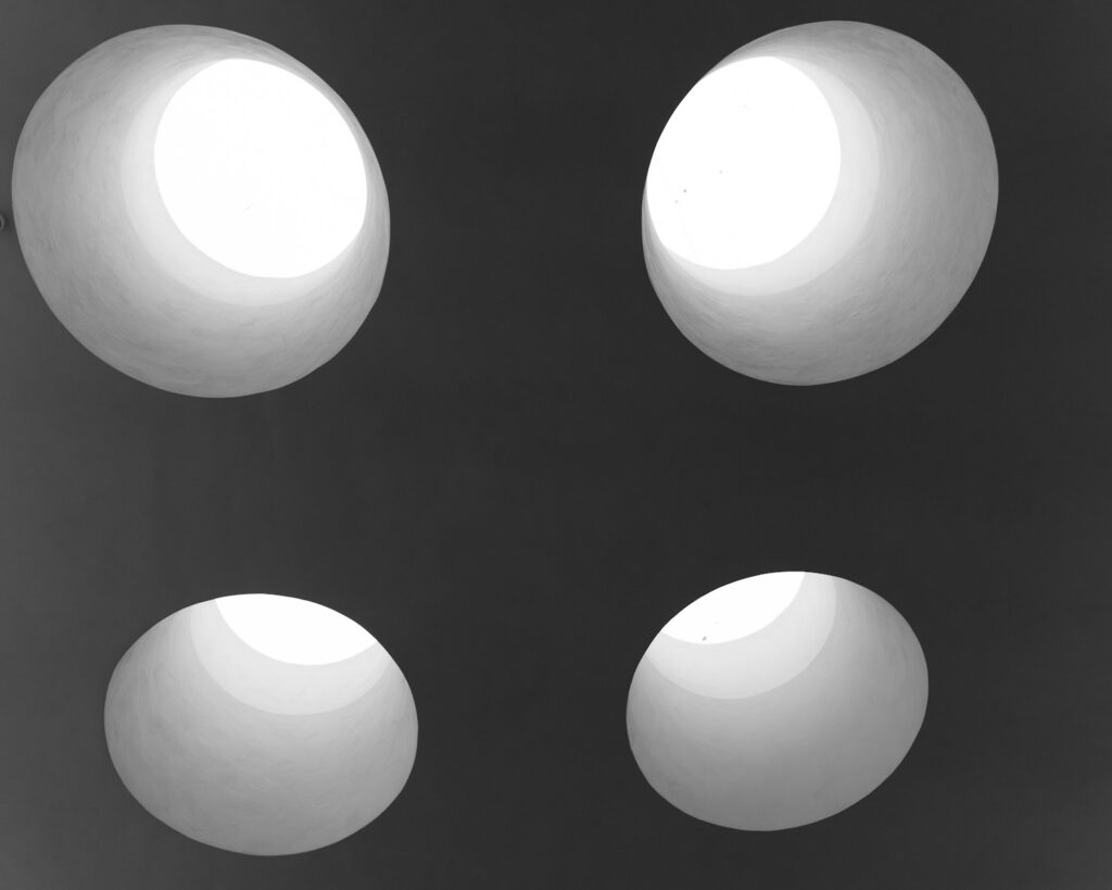 Four abstract, white, spherical shapes are shown.