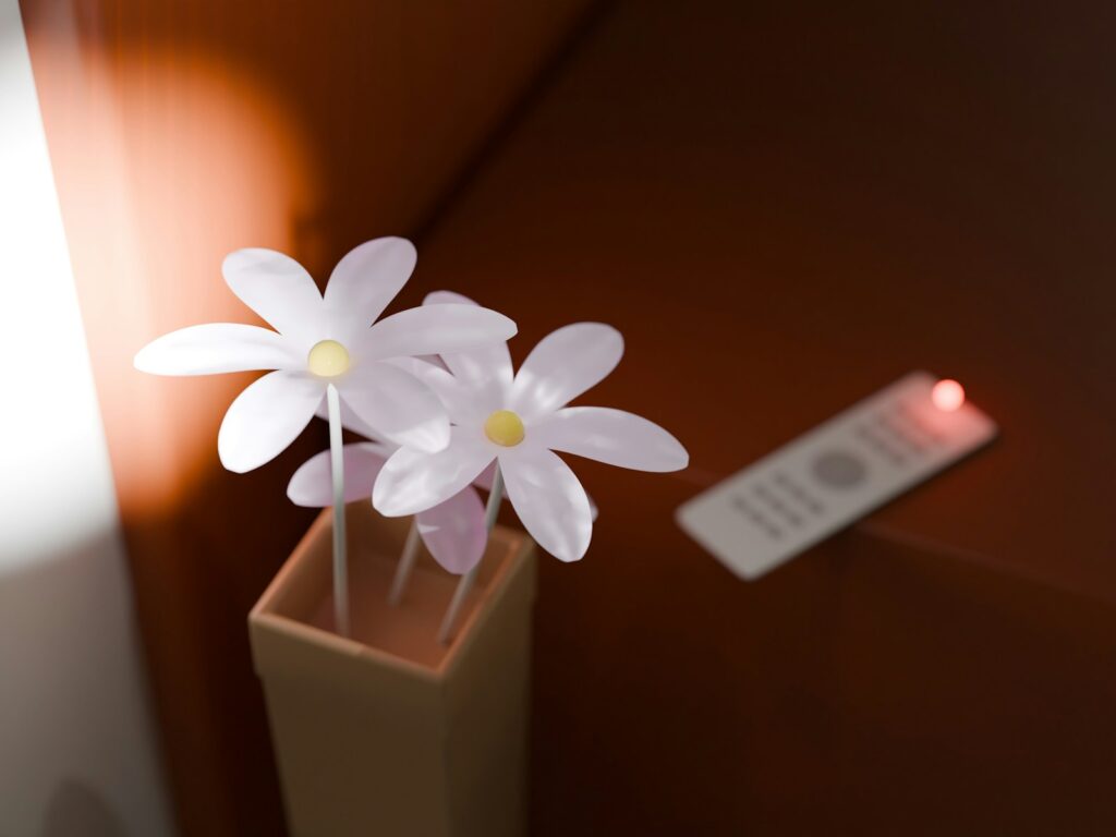 Flowers and a remote on a table.