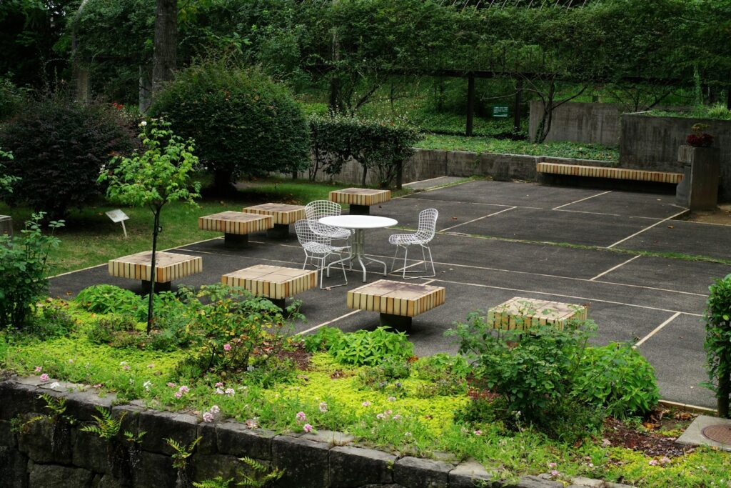 A patio with a table and chairs surrounded by greenery