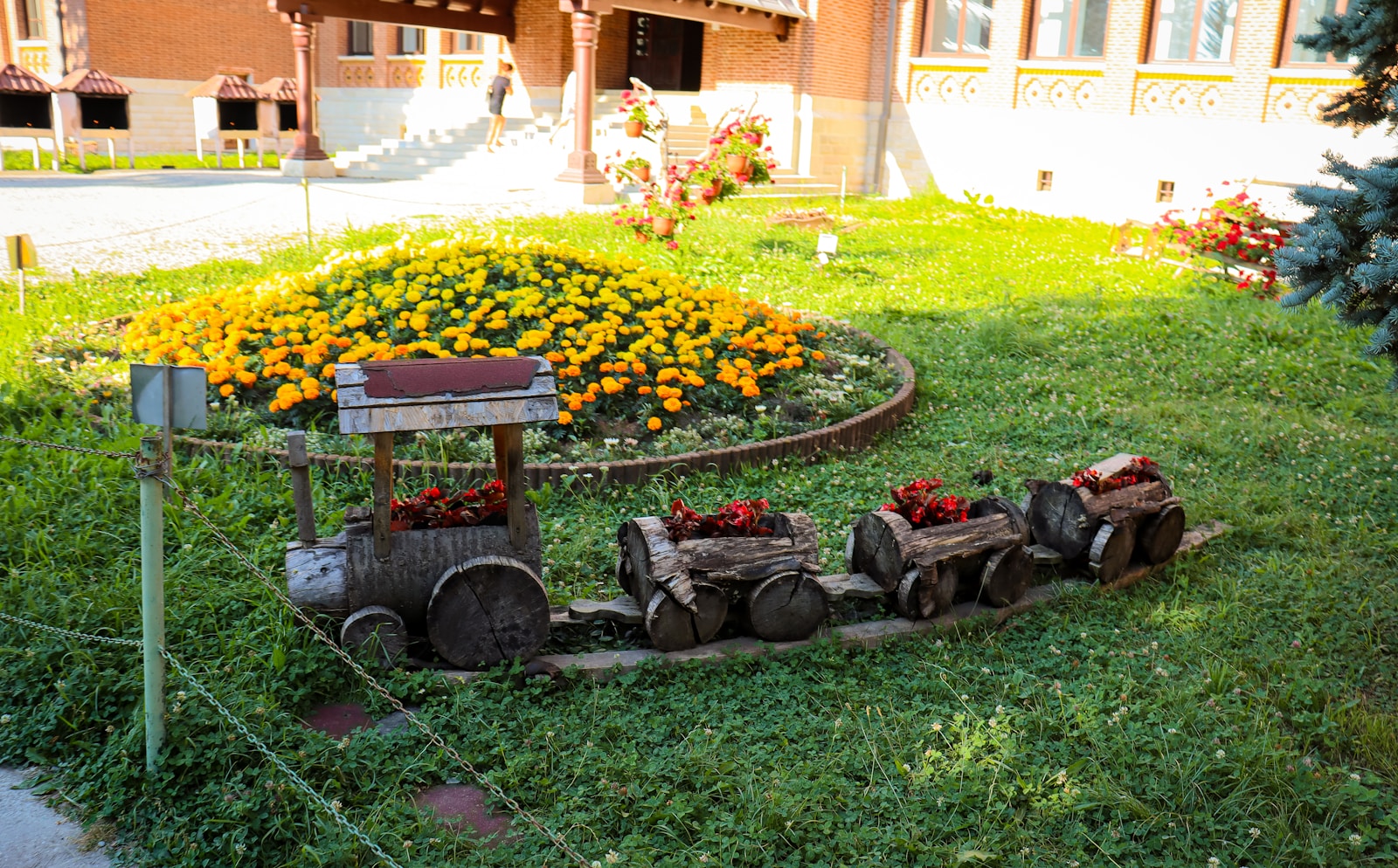 a train is sitting in the middle of a flower garden