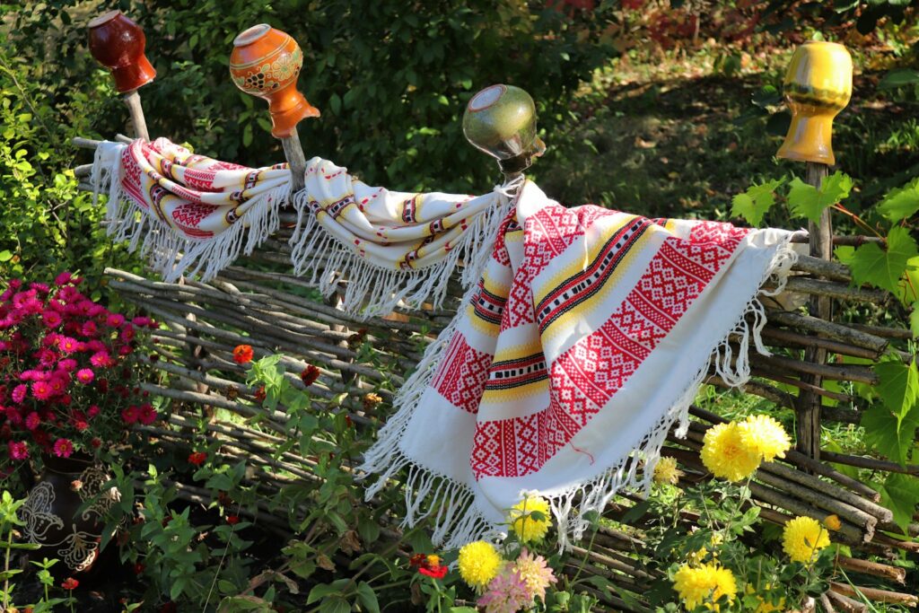 A blanket draped over a wooden bench in a garden
