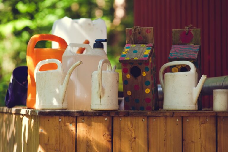 a wooden table topped with lots of white jugs and containers
