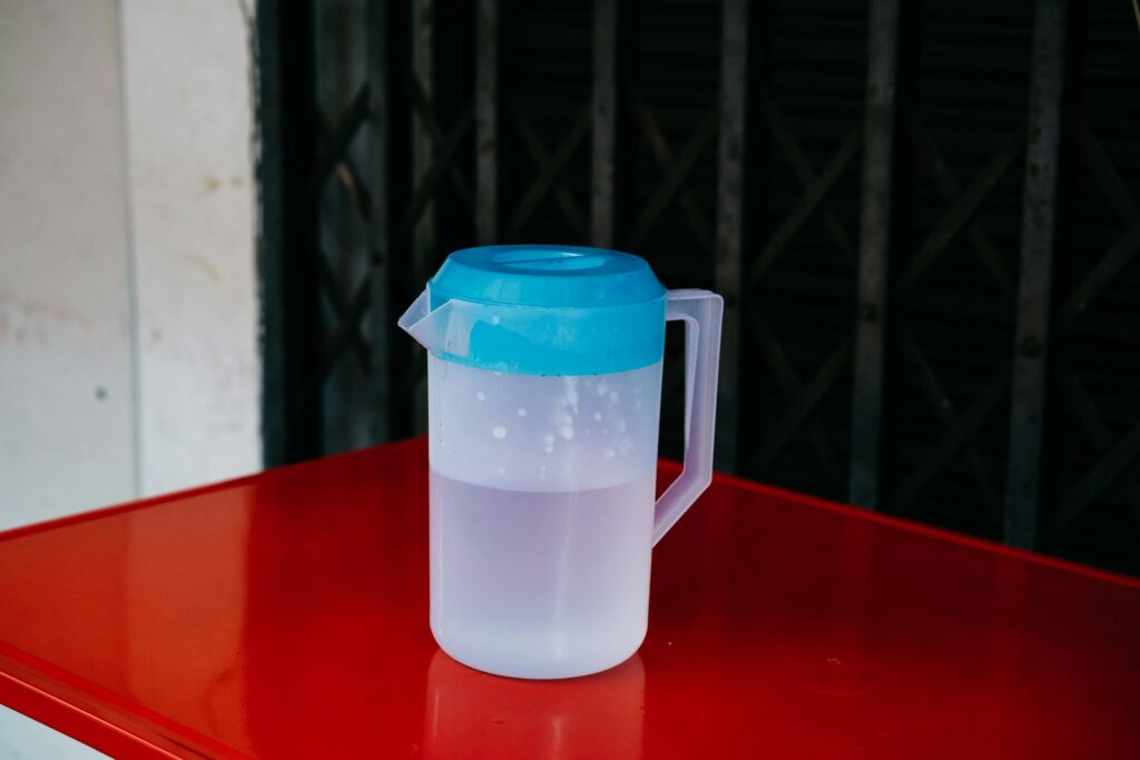 a plastic jug sitting on top of a red table