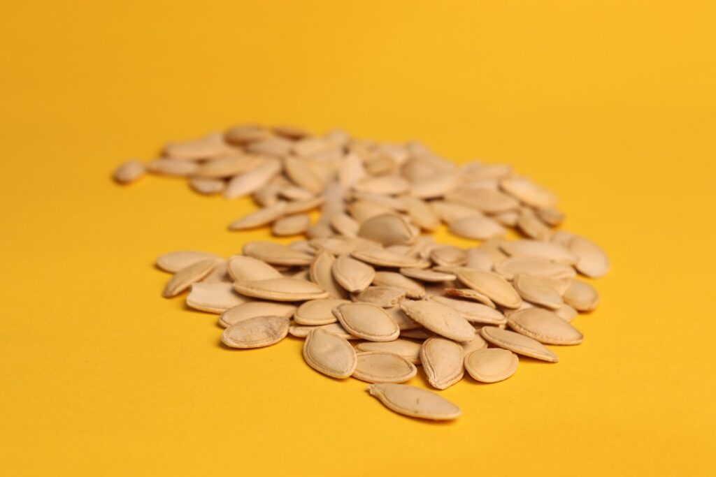 A pile of sunflower seeds on a yellow background