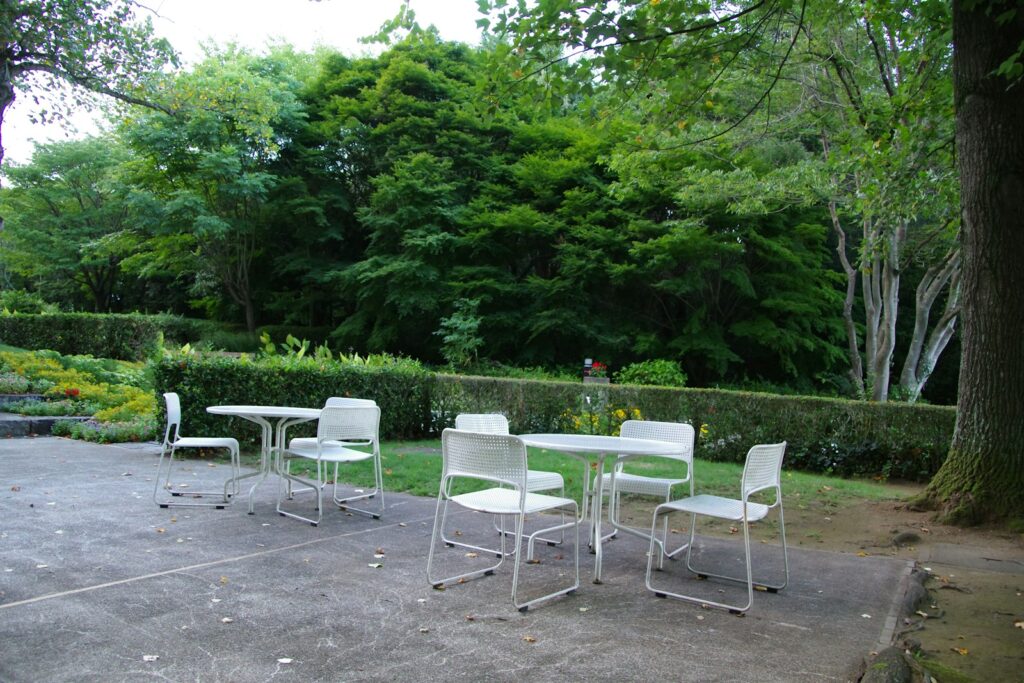 A group of white chairs sitting on top of a cement ground