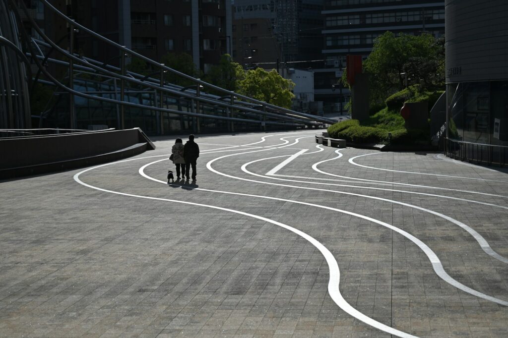 A couple of people walking down a street