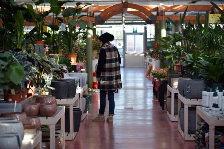 A vibrant interior of a modern plant shop showcasing a variety of houseplants, pots, and gardening supplies, creating an inviting green space.