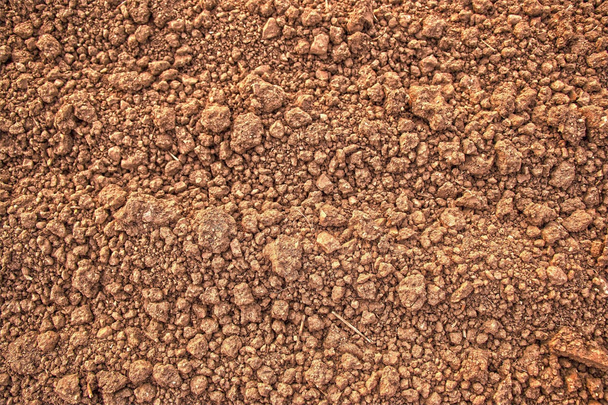 Detailed view of rough and dry brown soil, showcasing its natural texture.