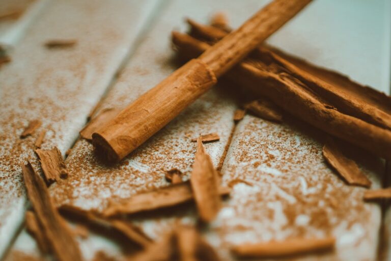A detailed close-up image of cinnamon sticks and ground cinnamon on a wooden surface, highlighting texture and aroma.