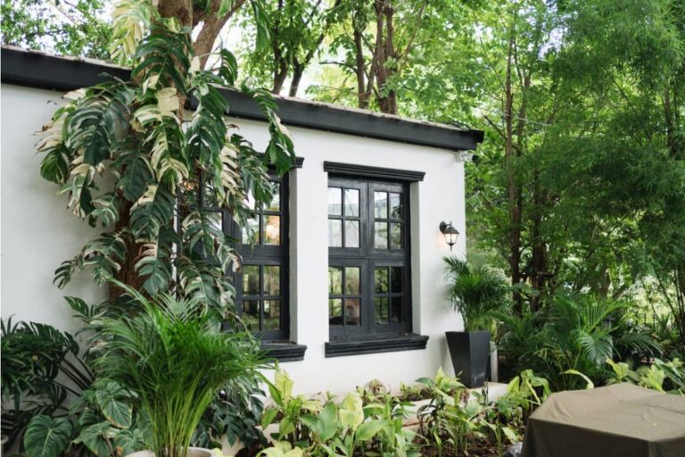Homeowner Says Her Neighbors Destroyed Fifteen Years of Her Tropical Garden, Then Became Terrified When She Hung Ten Tiny Figures Along the Fence