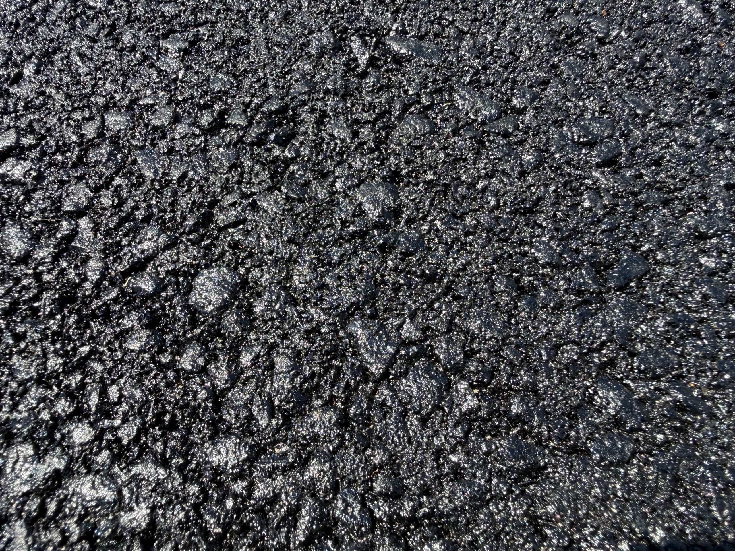 Fresh black asphalt on a newly paved residential driveway