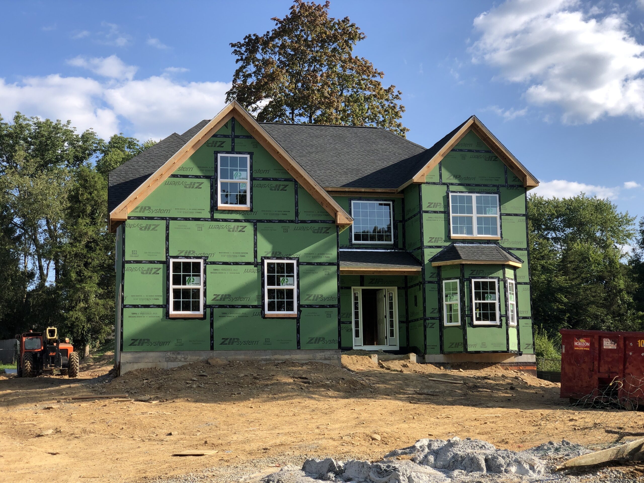 A new wood-frame house under construction with exposed framing and sheathing